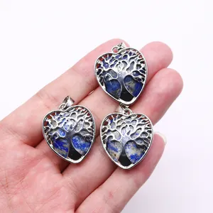 Silver tree of life heart pendant with natural blue lapis stone held in hand