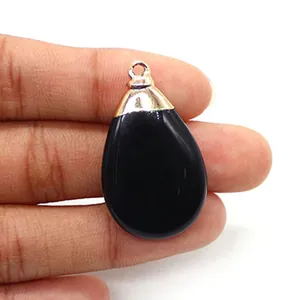 Close-up of black teardrop natural stone pendant with silver plated metal clasp