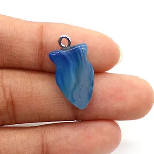 Macro-opname van een visvormige blauw gestreepte agaat hanger met maatvergelijking