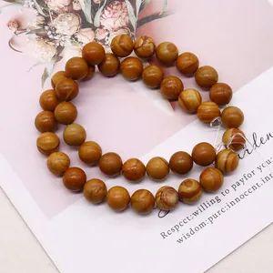 Βραχιόλι από φυσικές πέτρες Picture Jasper με γήινες καφέ υφές πάνω σε ένα περιοδικό