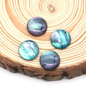 Τέσσερα στρογγυλά ιριδίζοντα cabochons από κοχύλι abalone σε φυσικό ξύλινο φόντο