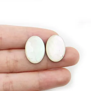 Makroaufnahme ovaler weißer Perlmutt-Cabochons mit irisierendem Glanz für DIY-Schmuck