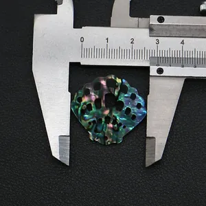 Détail macro du pendentif nacre d'abalone 26mm avec motif festonné évidé