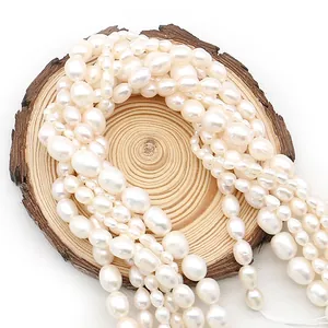 Natural white freshwater rice-shaped baroque pearls displayed on a rustic wood slice