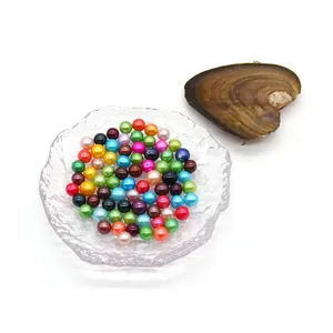 Colorful 6-8mm round pearls with natural luster displayed in a textured glass dish