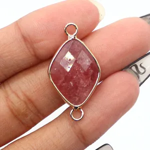 Macro shot of faceted pink strawberry quartz diamond connector with gold edges for DIY jewelry