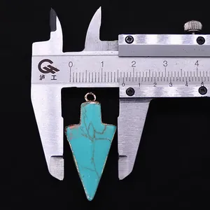 Gedetailleerde opname van turquoise pijlhanger van 1,6cm met een goudkleurige rand