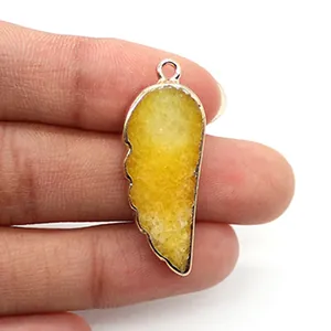 Macro d'un pendentif en cristal druzy jaune en forme d'aile avec bordure plaquée or