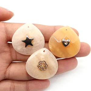 Detail of teardrop resin charms with gold metal star, heart, and rose inlay for DIY jewelry