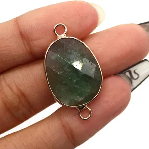 Detailed macro of oval green gemstone connector with rose gold plating for jewelry making