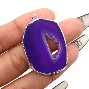 Detailed macro of a purple geode agate slice pendant with electroplated silver edges