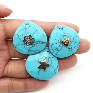 Detailed view of turquoise waterdrop pendants with gold flower, heart, and star metal motifs