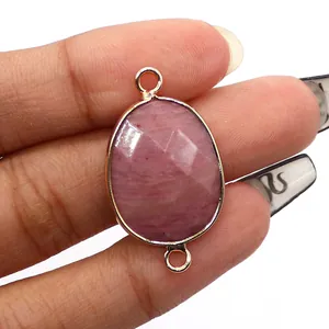 Detail view of faceted pink natural stone connector with gold plated double rings for jewelry