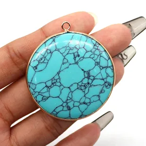Macro view of a large round turquoise pendant with gold trim and natural black veins
