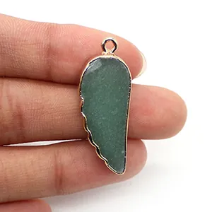 Détail du pendentif en pierre naturelle en forme d'aile avec bordure en métal doré