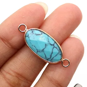 Detail van gefacetteerde ovale turquoise connector met vergulde lussen voor DIY sieraden