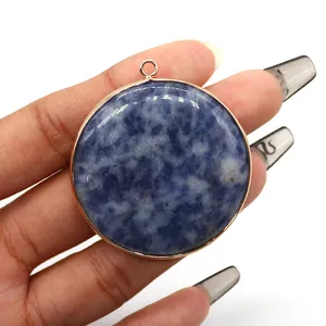 Macro detail of round natural blue stone pendant with rose gold plated metal edging decoration