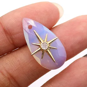 Macro shot of faceted teardrop purple crystal pendant with golden star and center zircon