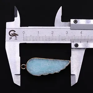 Pendentif en pierre naturelle forme plume bleue et bord doré mesurant 3,6 cm au pied à coulisse