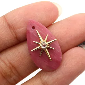 Detail of pink natural stone water-drop pendant with a golden sunburst crystal inlay