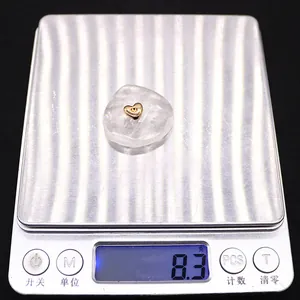 Detailed view of gold heart pendant weight measurement showing 8.3 grams on scale