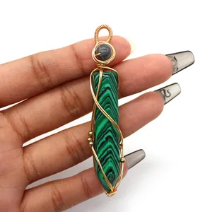 Macro detail of hexagonal malachite pendant with intricate golden wire wrapping