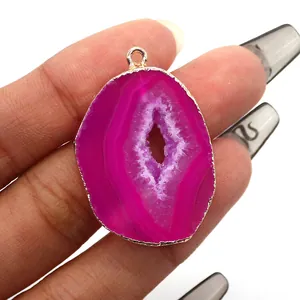 Detailed view of rose red irregular agate pendant with gold plated edges and crystal druzy