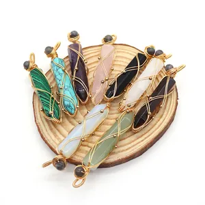 Handmade wire-wrapped hexagonal crystal pendants in natural stone on a wooden plate