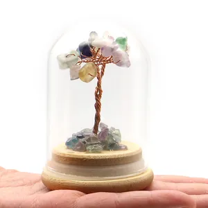 Primer plano de un árbol de dinero de cristal en cúpula de vidrio sostenido a mano
