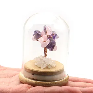 Detalle de un árbol de la fortuna de cristal púrpura en cúpula de vidrio en la mano