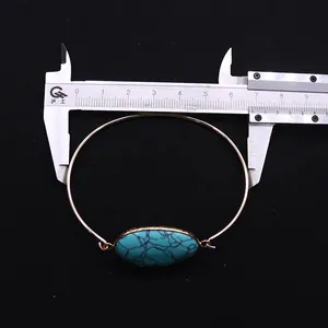 Detail view of gold turquoise open cuff bracelet with ruler showing 60mm diameter size