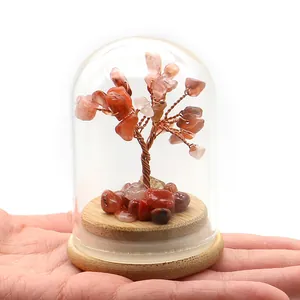 Detalle de mini árbol de cristal de ágata roja en cúpula de vidrio con base de madera