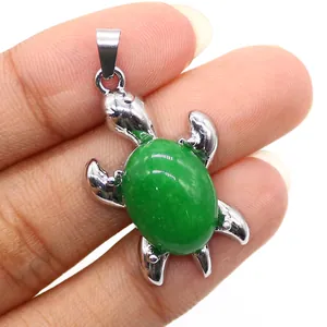 Dettaglio macro del ciondolo a forma di tartaruga in argento con gemma ovale verde