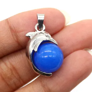Detailed view of silver dolphin pendant with blue round gemstone for DIY jewelry