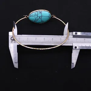 Measuring 6.0cm inner diameter of gold bangle with turquoise stone using a caliper