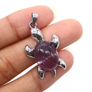 Primo piano di un ciondolo a tartaruga placcato in argento con guscio in cristallo di pietra viola