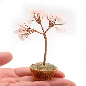 Primer plano de un árbol de cristal rosa hecho a mano sostenido para mostrar su tamaño mini