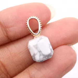 Macro shot of white turquoise faceted pendant with gold-plated decorative metal clasp