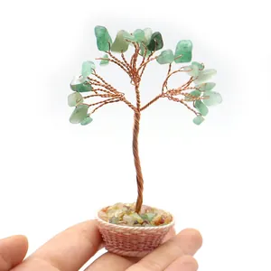 Miniatur Kristall-Geldbaum mit Kupferdraht und grünen Steinen, gehalten in der Hand