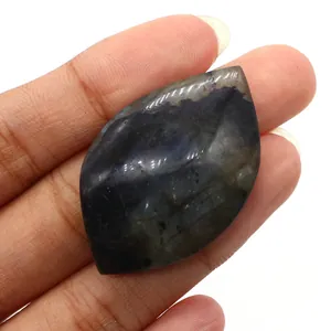 Macro shot of labradorite marquise leaf stone with blue flash held in fingers
