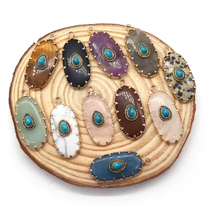 Oval natural stone pendants with gold edges and blue turquoise center set on wood