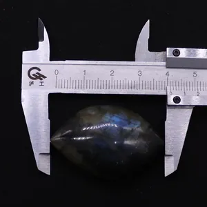 Macro view of marquise cut labradorite stone with blue flash measured by a caliper