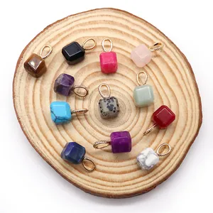 Set of 12 cube natural stone pendants with gold loops on a wooden display plate