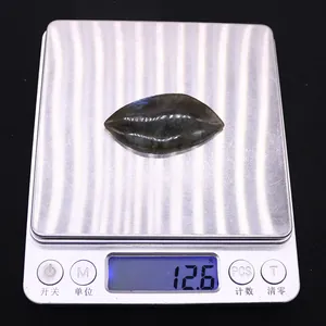 Close-up of a leaf-shaped labradorite stone showing 12.6g weight on a digital scale