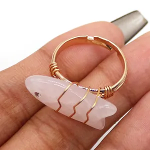 Detail van een rozenkwarts vissteen op een goudkleurige handgewikkelde verstelbare ring