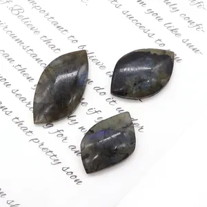 Three marquise-cut natural labradorite stones with blue flash on elegant background