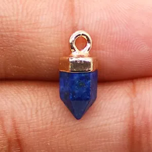 Macro-opname van gefacetteerde lapis lazuli zeshoekige hanger met gouden kap voor DIY-sieraden