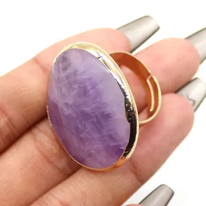 Primer plano de un anillo ajustable dorado con una piedra de amatista morada ovalada