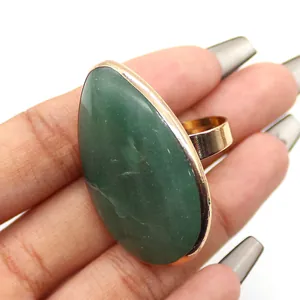 Vista detallada de un anillo con gran piedra verde en forma de gota y banda dorada ajustable