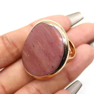 Vista macro de anillo de piedra natural ovalada con banda ajustable bañada en oro